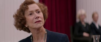 Movie still from “Woman in Gold” (2015), directed by Simon Curtis – An older woman wearing a black jacket and a necklace; Close Up shot, Over the shoulder angle