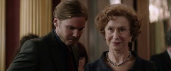 Movie still from “Woman in Gold” (2015), directed by Simon Curtis – A man standing next to an older woman in a room; Close Up shot, Over the shoulder angle