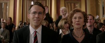 Movie still from “Woman in Gold” (2015), directed by Simon Curtis – A group of people in a room with a crowd of onlookers; Close Up shot, Over the shoulder angle
