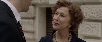 Movie still from “Woman in Gold” (2015), directed by Simon Curtis – An older woman wearing a necklace and a black jacket; Close Up shot, Over the shoulder angle