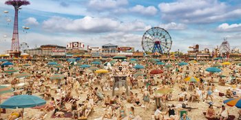 Movie still from “Wonder Wheel” (2017), directed by Woody Allen – A crowd of people sitting on top of a sandy beach; Extreme Wide shot, High angle