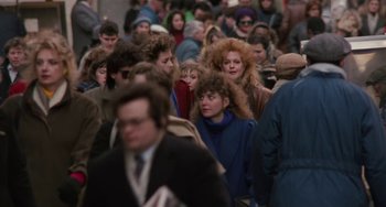 Movie still from “Working Girl” (1988), directed by Mike Nichols – A crowd of people walking down a street; Medium shot, High angle