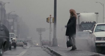 Movie still from “Working Girl” (1988), directed by Mike Nichols – A woman walking down a street in the fog; Wide shot, Low angle