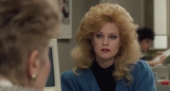 Movie still from “Working Girl” (1988), directed by Mike Nichols – A woman in a blue jacket looking into a mirror; Close Up shot, Over the shoulder angle