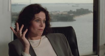 Movie still from “Working Girl” (1988), directed by Mike Nichols – A woman sitting in an office chair in front of the ocean; Close Up shot, Over the shoulder angle