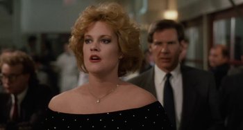 Movie still from “Working Girl” (1988), directed by Mike Nichols – A man and a woman are walking in a crowd; Close Up shot, Over the shoulder angle