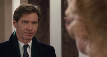Movie still from “Working Girl” (1988), directed by Mike Nichols – A man wearing a suit and tie in front of a mirror; Close Up shot, Over the shoulder angle
