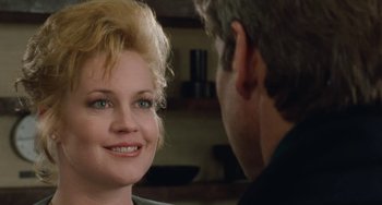 Movie still from “Working Girl” (1988), directed by Mike Nichols – A man and a woman smiling at each other; Close Up shot, Over the shoulder angle