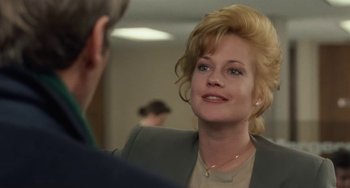 Movie still from “Working Girl” (1988), directed by Mike Nichols – A person wearing a suit and tie; Close Up shot, Over the shoulder angle