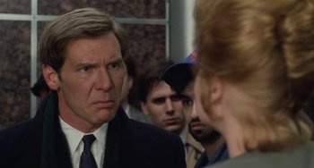 Movie still from “Working Girl” (1988), directed by Mike Nichols – A group of people standing next to each other in a room; Close Up shot, Over the shoulder angle