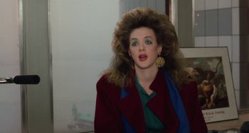Movie still from “Working Girl” (1988), directed by Mike Nichols – A woman in a red jacket with big hair and green eyes; Close Up shot, Over the shoulder angle