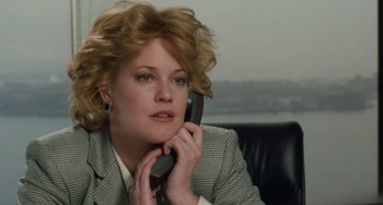 Movie still from “Working Girl” (1988), directed by Mike Nichols – A woman in a suit talking on a phone; Close Up shot, Low angle