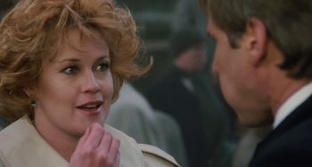 Movie still from “Working Girl” (1988), directed by Mike Nichols – A woman is smiling at the camera while a man looks at her; Close Up shot, Over the shoulder angle