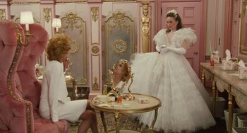 Movie still from “Working Girl” (1988), directed by Mike Nichols – Two women and a man in a room with pink walls; Wide shot, Over the shoulder angle