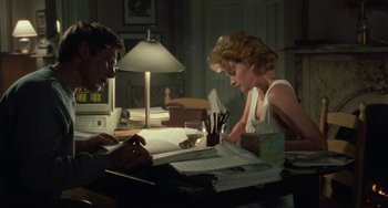 Movie still from “Working Girl” (1988), directed by Mike Nichols – A man and a woman sitting at a table; Medium shot, High angle