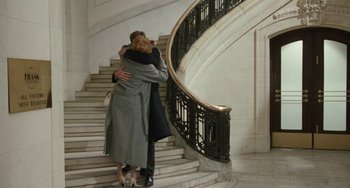 Movie still from “Working Girl” (1988), directed by Mike Nichols – A man and a woman hugging on the steps of a staircase; Wide shot, High angle