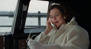 Movie still from “Working Girl” (1988), directed by Mike Nichols – A woman talking on a phone while sitting in a car; Medium shot, Low angle