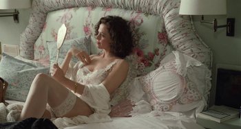 Movie still from “Working Girl” (1988), directed by Mike Nichols – A woman in white lingerie sitting on a bed; Medium shot, High angle