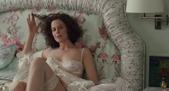 Movie still from “Working Girl” (1988), directed by Mike Nichols – A woman in white lingerie laying on a floral couch; Medium shot, Overhead angle