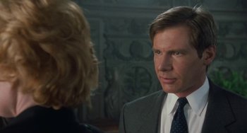 Movie still from “Working Girl” (1988), directed by Mike Nichols – A man in a suit and tie talking to a woman in a suit; Close Up shot, Over the shoulder angle