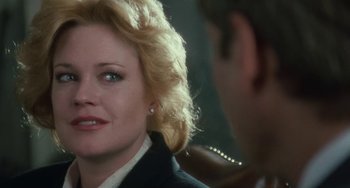 Movie still from “Working Girl” (1988), directed by Mike Nichols – A person wearing a suit; Close Up shot, Over the shoulder angle