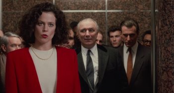 Movie still from “Working Girl” (1988), directed by Mike Nichols – A group of men and a woman standing next to each other; Medium shot, Low angle