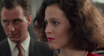 Movie still from “Working Girl” (1988), directed by Mike Nichols – A woman that is wearing a red dress; Close Up shot, Over the shoulder angle