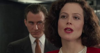 Movie still from “Working Girl” (1988), directed by Mike Nichols – A man and a woman standing next to each other; Close Up shot, Over the shoulder angle