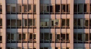 Movie still from “Working Girl” (1988), directed by Mike Nichols – A building with many windows and many people in it; Extreme Wide shot, High angle
