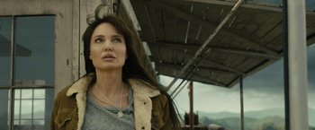 Movie still from “Wrong Turn” (2021), directed by Mike P. Nelson – A woman standing in front of a building with her eyes wide open; Close Up shot, Low angle