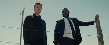 Movie still from “Wrong Turn” (2021), directed by Mike P. Nelson – A couple of men standing next to each other near barbed wire; Medium shot, Low angle