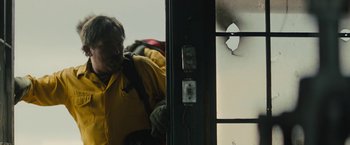 Movie still from “Wrong Turn” (2021), directed by Mike P. Nelson – A man in a yellow jacket standing in front of an open door; Close Up shot, Low angle