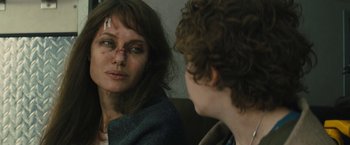 Movie still from “Wrong Turn” (2021), directed by Mike P. Nelson – A woman with a bruised face looking in a mirror; Close Up shot, Over the shoulder angle