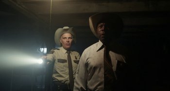Movie still from “X” (2022), directed by Ti West – A couple of men standing next to each other in a room; Medium shot, Low angle