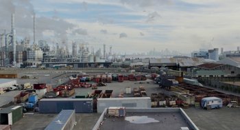 Movie still from “X” (2022), directed by Ti West – An aerial view of an industrial area in a large city; Extreme Wide shot, High angle
