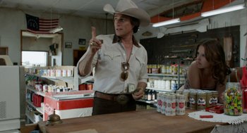 Movie still from “X” (2022), directed by Ti West – A man wearing a cowboy hat is standing at a counter; Medium shot, Over the shoulder angle