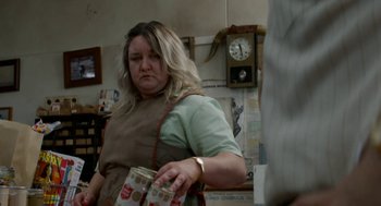 Movie still from “X” (2022), directed by Ti West – A woman in an apron is holding boxes of milk; Medium shot, Over the shoulder angle