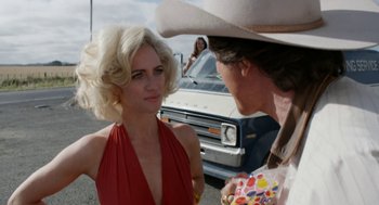 Movie still from “X” (2022), directed by Ti West – A woman in a red dress talking to a man in a cowboy hat; Close Up shot, Over the shoulder angle