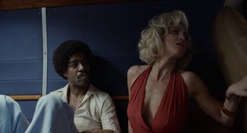 Movie still from “X” (2022), directed by Ti West – A man and a woman sitting next to each other; Medium shot, Low angle