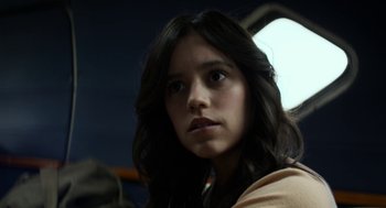 Movie still from “X” (2022), directed by Ti West – A woman with long black hair is looking at the camera; Close Up shot, Over the shoulder angle