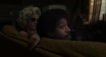 Movie still from “X” (2022), directed by Ti West – A man and a woman sitting on a couch together; Close Up shot, Low angle