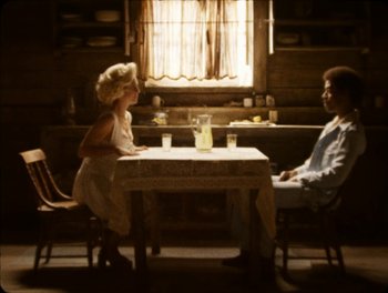 Movie still from “X” (2022), directed by Ti West – A man and a woman sitting at a dinner table; Wide shot, High angle