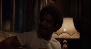 Movie still from “X” (2022), directed by Ti West – A man with a beard is smiling for the camera; Close Up shot, Over the shoulder angle