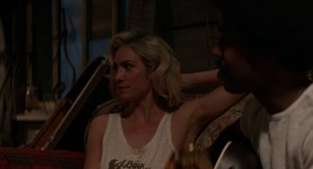 Movie still from “X” (2022), directed by Ti West – A woman sitting next to a man in front of a guitar; Medium shot, Over the shoulder angle