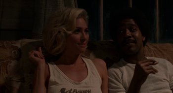 Movie still from “X” (2022), directed by Ti West – A woman sitting next to a man on a couch; Medium shot, Over the shoulder angle