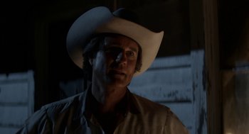 Movie still from “X” (2022), directed by Ti West – A man wearing a cowboy hat in a dark room; Close Up shot, Low angle