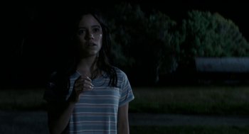 Movie still from “X” (2022), directed by Ti West – A woman standing in the dark with a cigarette in her hand; Close Up shot, Over the shoulder angle
