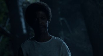 Movie still from “X” (2022), directed by Ti West – A man in a white t - shirt is standing in the dark; Close Up shot, Low angle
