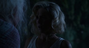 Movie still from “X” (2022), directed by Ti West – A woman with blonde hair is standing in the dark; Close Up shot, Over the shoulder angle
