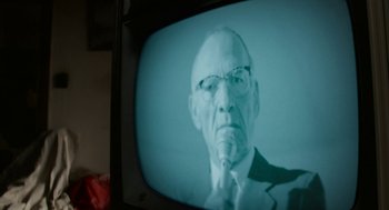 Movie still from “X” (2022), directed by Ti West – An old man wearing glasses is on a television screen; Close Up shot, Low angle